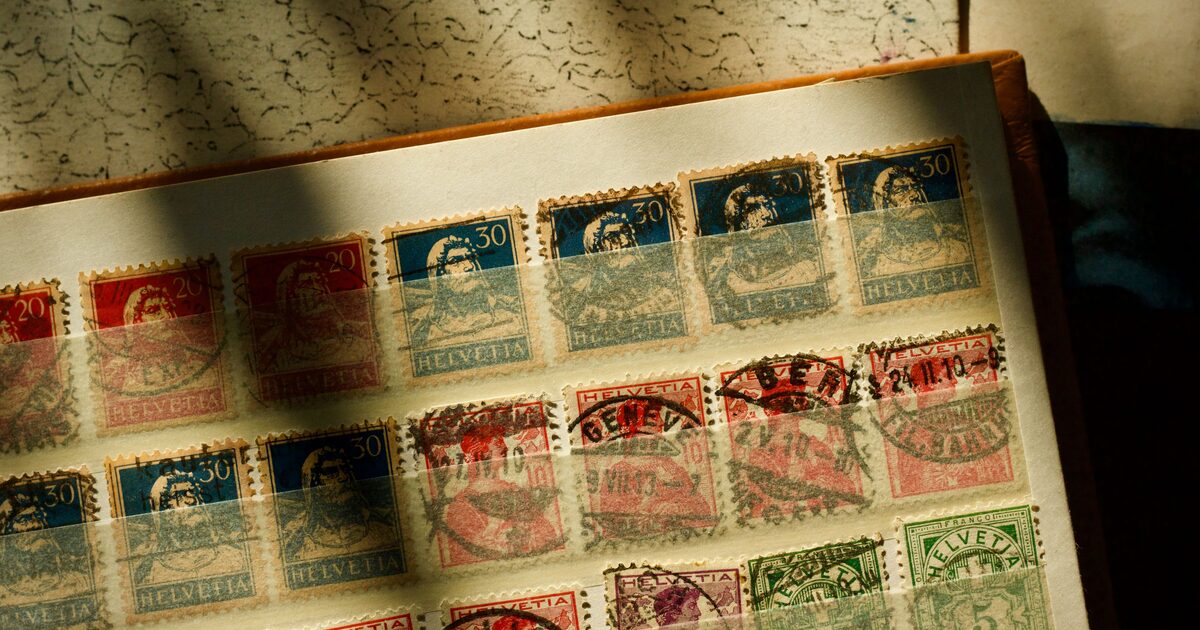 A sunlit album page of vintage Swiss postage stamps